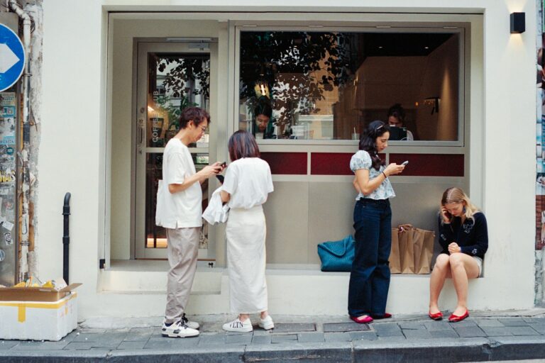 People outside cafe looking at phones